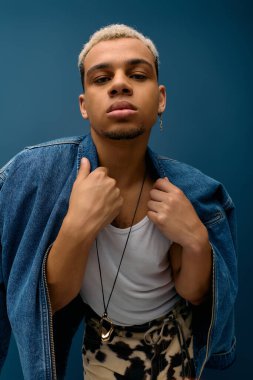 Genç Afro-Amerikalı adam modaya uygun kot ceketiyle poz veriyor..