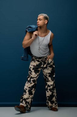 Genç adam kendine güvenen bir pozla boyalı saçlar, modern moda ve stil havası sergiliyor..