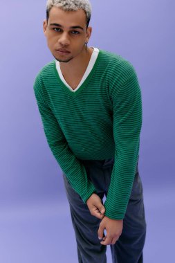 Genç Afrikalı Amerikalı adam, modaya uygun bir kıyafetle kendine güvenerek poz veriyor. Havalı bir tarz ve karizma..