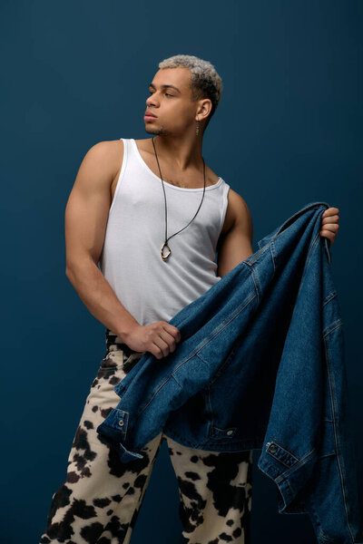 A fashionable young man with dyed hair confidently poses in a trendy denim jacket.