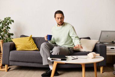 Rahat bir oturma odasında dinlenen genç bir adam, gününü yansıtırken içkisinin tadını çıkarıyor..