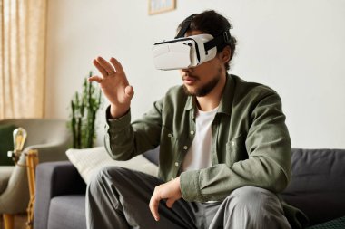 Genç yakışıklı bir adam evinde rahat bir şekilde otururken sanal dünyaları keşfetmekten zevk alır..