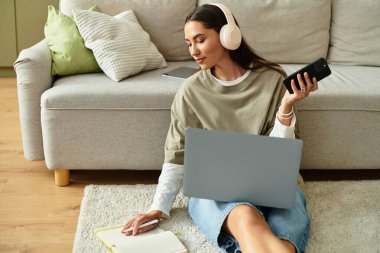 Güzel genç bir kadın evde dinleniyor, kulaklık takıp işine odaklanıyor..