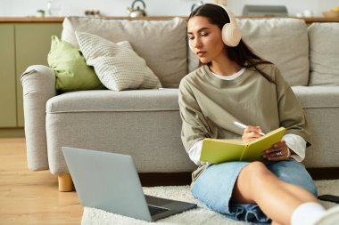 Güzel genç bir kadın evde dinlenir, müzik dinlerken notlar alır..