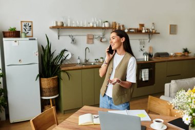 Parlak ve ferah mutfak bitkilerle dolu. Genç bir kadın telefonuyla mutlu bir şekilde sohbet ediyor..