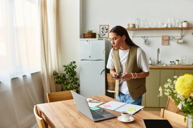 Etrafı bitkilerle çevrili genç bir kadın, sıcak ev atmosferinin keyfini çıkarırken özenle çalışıyor..