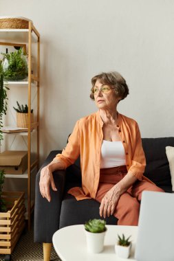 Yaşlı kadın, rahat evinde, bitkiler ve konforla dolu bir anın tadını çıkarıyor..