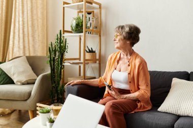 Kıdemli kadın rahat giyiniyor ve evdeki huzurlu havanın tadını çıkarıyor..