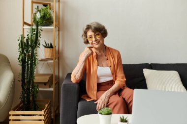 Son sınıf öğrencisi bir kadın rahat bir kıyafetle kanepede dinleniyor ve huzurlu evinin tadını çıkarıyor..