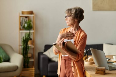 Kıdemli kadın sıcak ve rahat içinde, düşünceli bir şekilde evinde oturuyor..