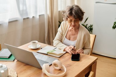 Rahat bir odada, rahat giysiler içindeki son sınıf öğrencisi kahve içerek gününü yansıtıyor..