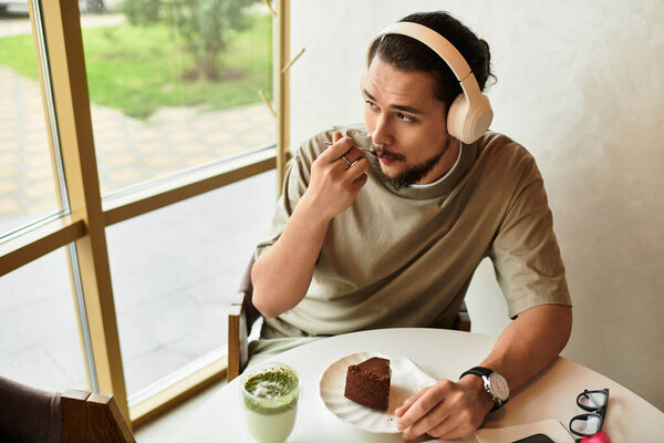 Young man enjoying matcha and cake in a cozy summer cafe.