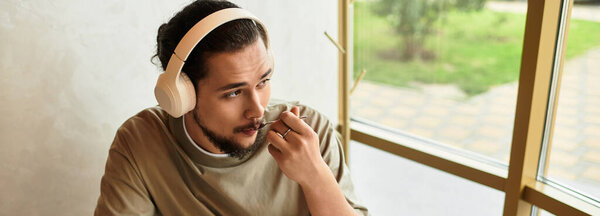 A young man with a beard enjoying taste of cake in cafe, banner