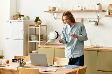 Yakışıklı bir genç adam, yaratıcı görevlere dalmış bir masanın başında duruyor, evde geçirdiği anların tadını çıkarıyor..