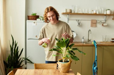 Yakışıklı genç adam evinde huzurlu bir anın tadını çıkarırken gelişmekte olan bir bitkiyi suluyor..