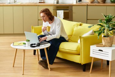 Parlak ve davetkar bir yerde dizüstü bilgisayarla çalışırken sıcak bir içkinin tadını çıkarıyorum..