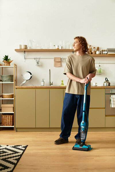 Handsome young man vacuums his stylish kitchen in comfort, soaking in a peaceful moment.