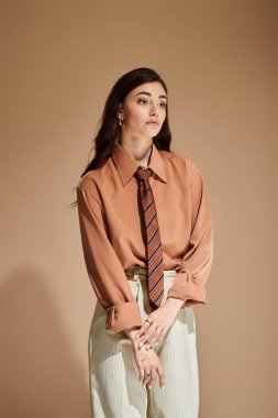 Güzel genç bir kadın şık kıyafetlerini bir fotoğraf çekiminde moda bir stüdyoda sergiliyor..