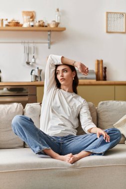 Kahverengi saçlı genç bir kadın evinde rahatça dinleniyor..