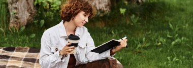 Kıvırcık saçlı genç bir kadın, doğayla iç içeyken bir kitabın tadını çıkarıyor.