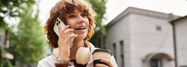 Kıvırcık saçlı genç kadın telefonda konuşuyor, gülümsüyor ve elinde kahve tutuyor, afiş.