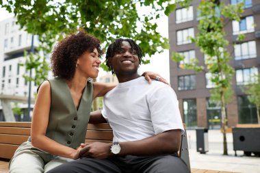 Genç bir çift birlikte dışarıda eğlenirken kahkaha ve şefkat paylaşıyor..