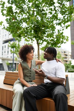 İki modaya uygun genç güneşli bir şehir gününde neşeli bir sohbeti paylaşıyor..