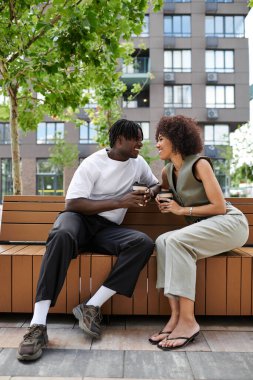 Şık giyimli çift güzel bir şehir sabahında içkilerini ve gülüşlerini paylaşıyor..