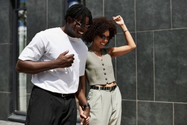 Genç Afrikalı Amerikalı çiftler el ele geziyor, gülüyorlar ve yaz havasının tadını çıkarıyorlar..