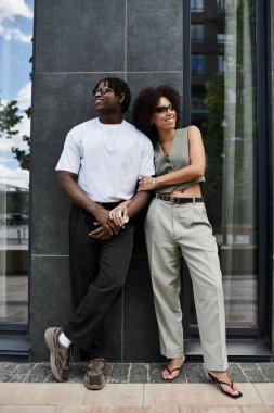 Şık bir Afrikalı Amerikalı çift, şehirde bir yaz günü buluşmasında hafif bir anı paylaşıyor.