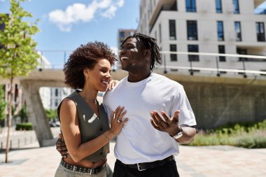 Şık, genç bir çift güneşli bir şehir buluşmasında neşeli anlar paylaşır..