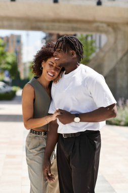 Modaya bağlı bir çift, şehir manzarasında dolaşırken aynı kahkahayı ve sevgiyi paylaşıyor..