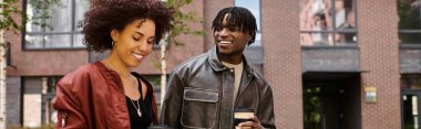 Afro-Amerikan çifti şehirde yürürken neşeli bir anı paylaşıyor.