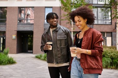 Moda kıyafetleri içinde genç bir çift birlikte yürüyorlar, şehirde eğleniyorlar..