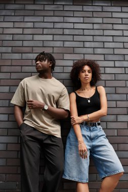 Şık giyimli genç çift canlı bir şehirde rahat bir anı paylaşıyor..