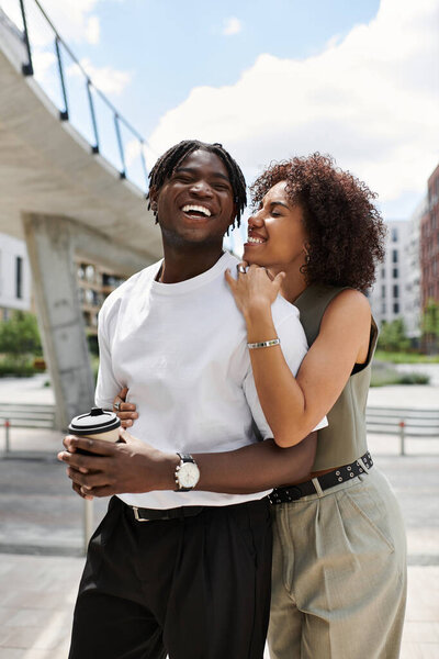 Молодая пара улыбается и делится радостным моментом, исследуя городской пейзаж вместе.