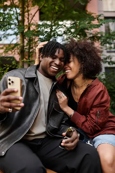 Neşeli genç çift gülüyor ve şehir buluşmalarında hassas bir anı paylaşıyorlar.