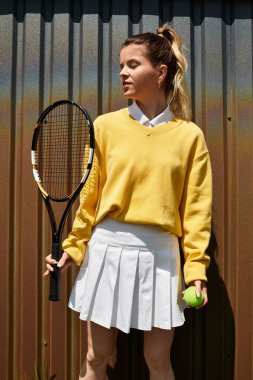 Tenis için giyinmiş, kendine güven ve neşe saçan genç bir kadınla hayat dolu bir yaz günü..