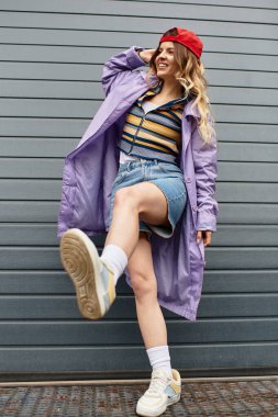 Neşeli genç kadın yaz kıyafetleri içinde kendine güvenerek duruyor, pozitiflik ve tarz yayıyor..