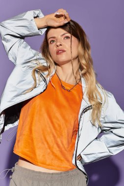 Genç bir kadın rengarenk bir arkaplan karşısında şık kıyafetiyle yaz havası yayıyor..