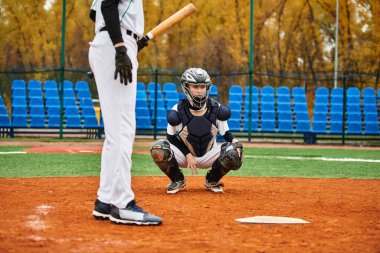 İki çocuk, çimenli bir sahada etek giyerken heyecan verici bir beyzbol maçına katılıyor..