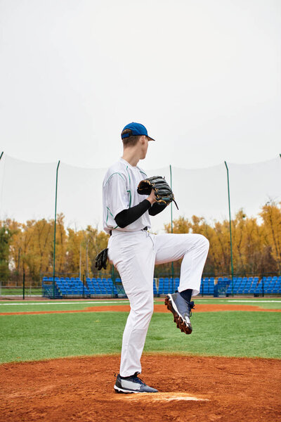 Спортсмен на бейсбольном поле готовится к подаче с решимостью под облачным небом.