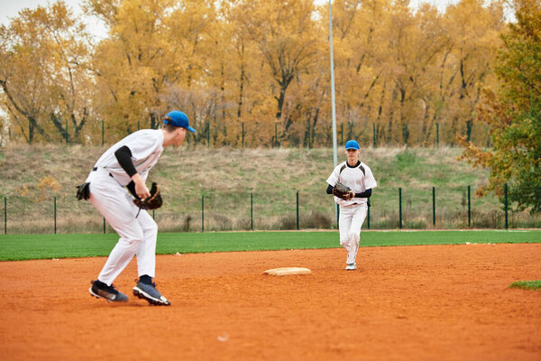 Два подростка, участвующих в товарищеском бейсболе, демонстрируют свои спортивные навыки.