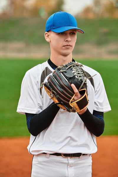 A talented athlete stands ready to pitch on the baseball field under clear skies.