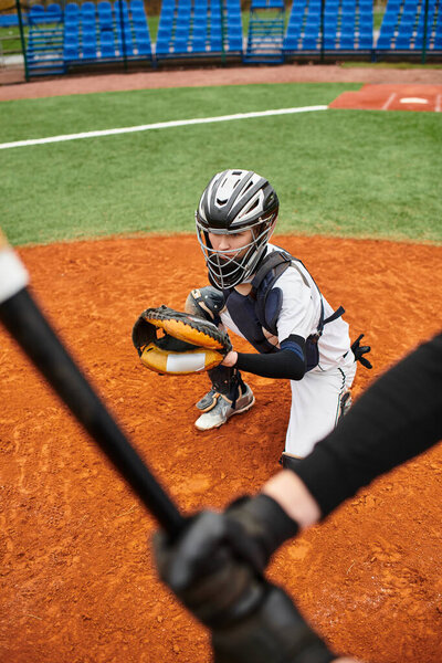 Два мальчика страстно играют в бейсбол на ярком зеленом поле в теплый день.