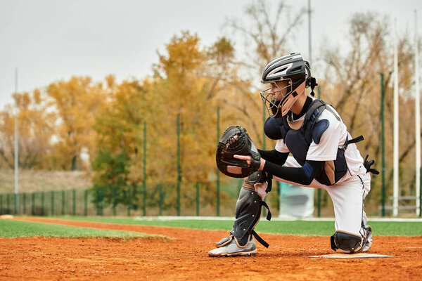 Young player focusing intently as he catches a baseball on a crisp autumn afternoon.