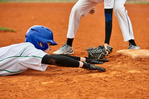 Два подростка участвуют в захватывающей бейсбольной игре на солнечном поле, демонстрируя атлетику.