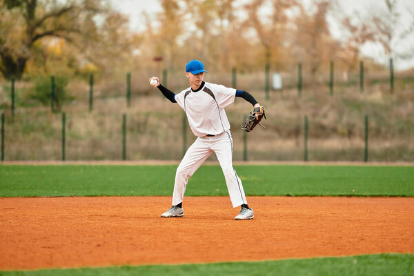 A young athlete demonstrates his pitching technique on an autumn day at the baseball field.