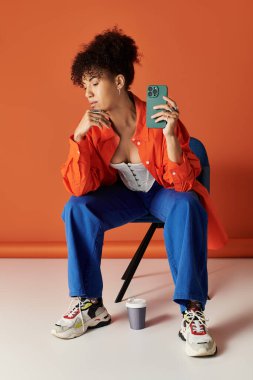 Kıvırcık saçlı şık bir kadın, canlı bir stüdyo ortamında aletleriyle meşgul oluyor..