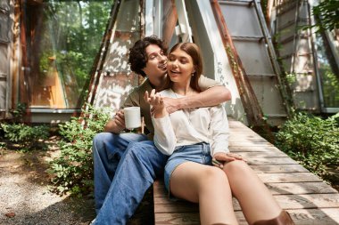 Genç bir çift, dışarıda dinlenirken sıcaklığı ve kahkahayı paylaşarak birbirlerine eşlik etmekten zevk alır..